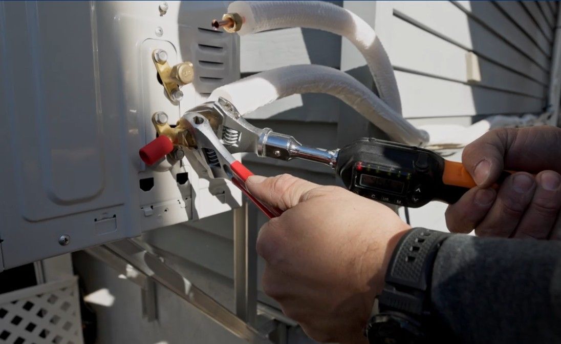 Des mains utilisent des pinces pour travailler sur le câblage