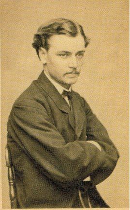 a man in a suit and tie is sitting in a chair with his arms crossed .