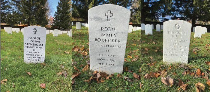 three graves in a cemetery with a cross on them
