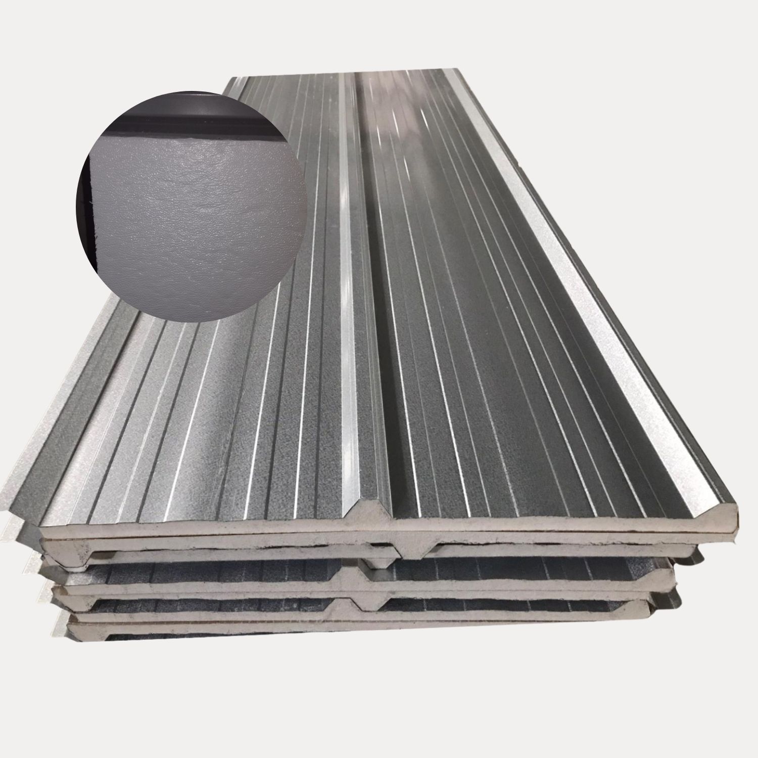 Paneles aislantes de metal apilados con un primer plano de la superficie texturizada, probablemente para construcción.