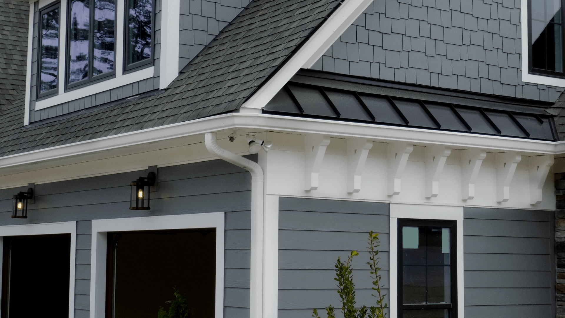 A gray house with a black roof and white trim