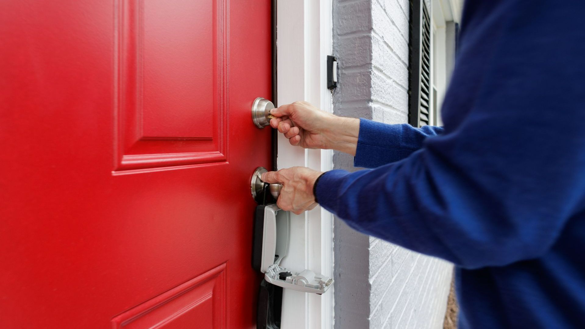 A Person Is Opening a Red Door with A Key | Westminster, CO | M.L. Locksmith A Person Is Opening a Red Door with A Key | Westminster, CO | M.L. Locksmith