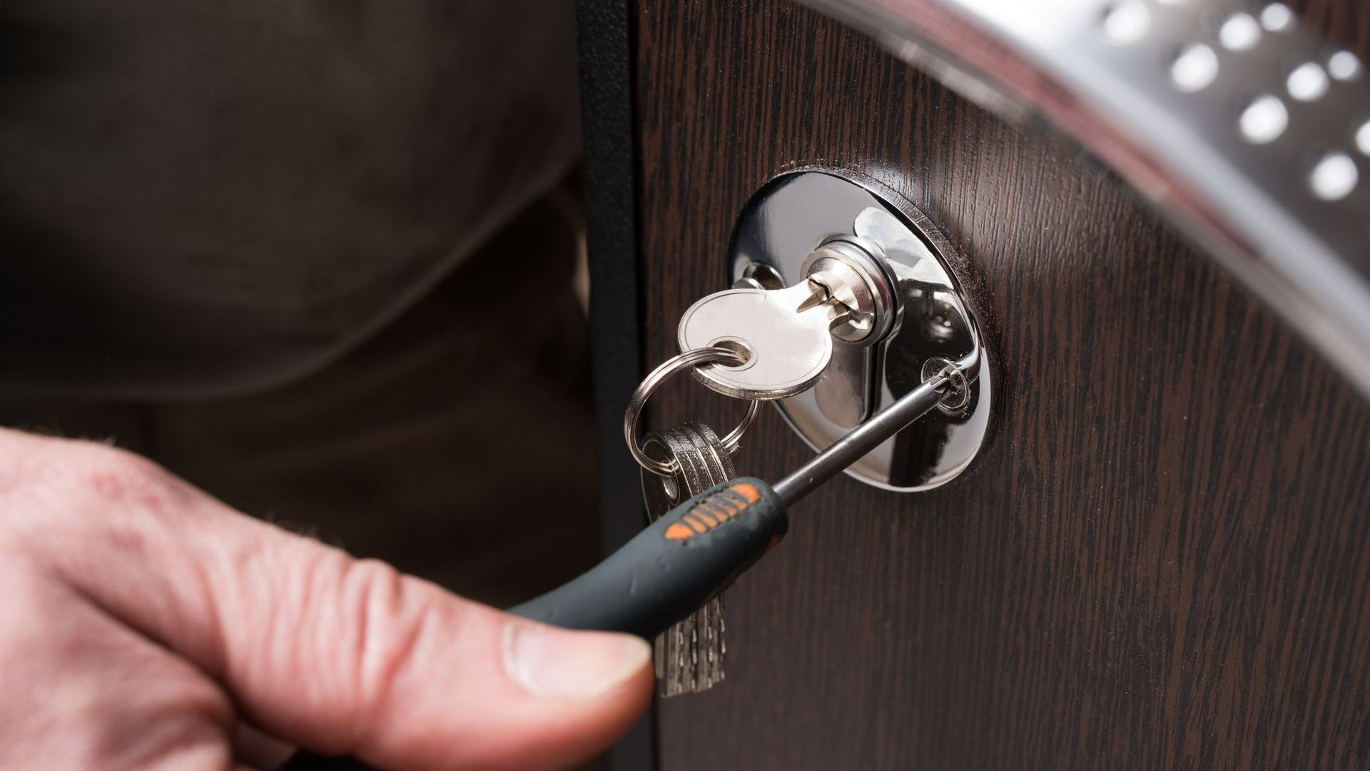 A Person Is Fixing a Door Lock with A Key | Westminster, CO | M.L. Locksmith A Person Is Fixing a Door Lock with A Screwdriver | Westminster, CO | M.L. Locksmith