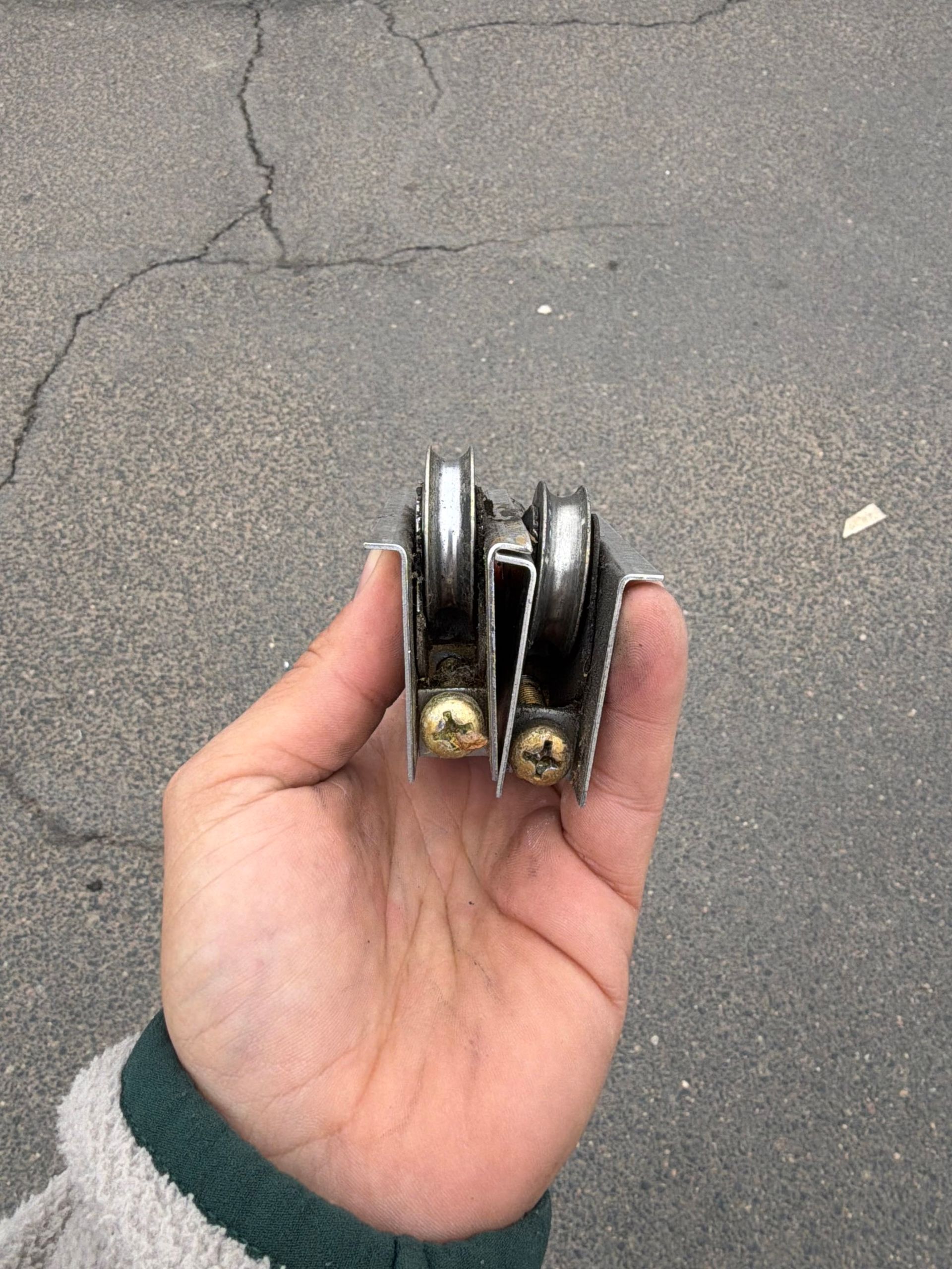 Close‑up of sliding door roller replacement in a Denver home with a hand and tool.