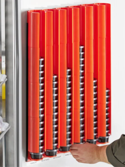 Red tool holder on a wall; hand pulls a tool. Silver tools are visible inside the holder.