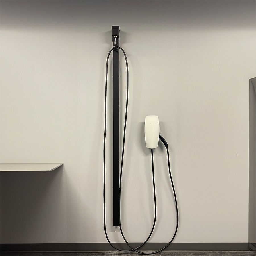 The Wall Retraction Unit by Wattz Up holds the cable of a Tesla charger to show its' capabilities.
