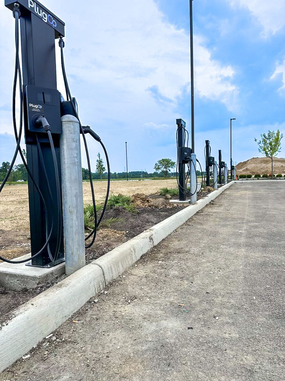 Three Standard Wattz Up EV Charging Pedestals hold two EV chargers each in public parking.