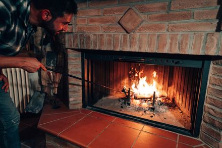Man tending a fireplace.