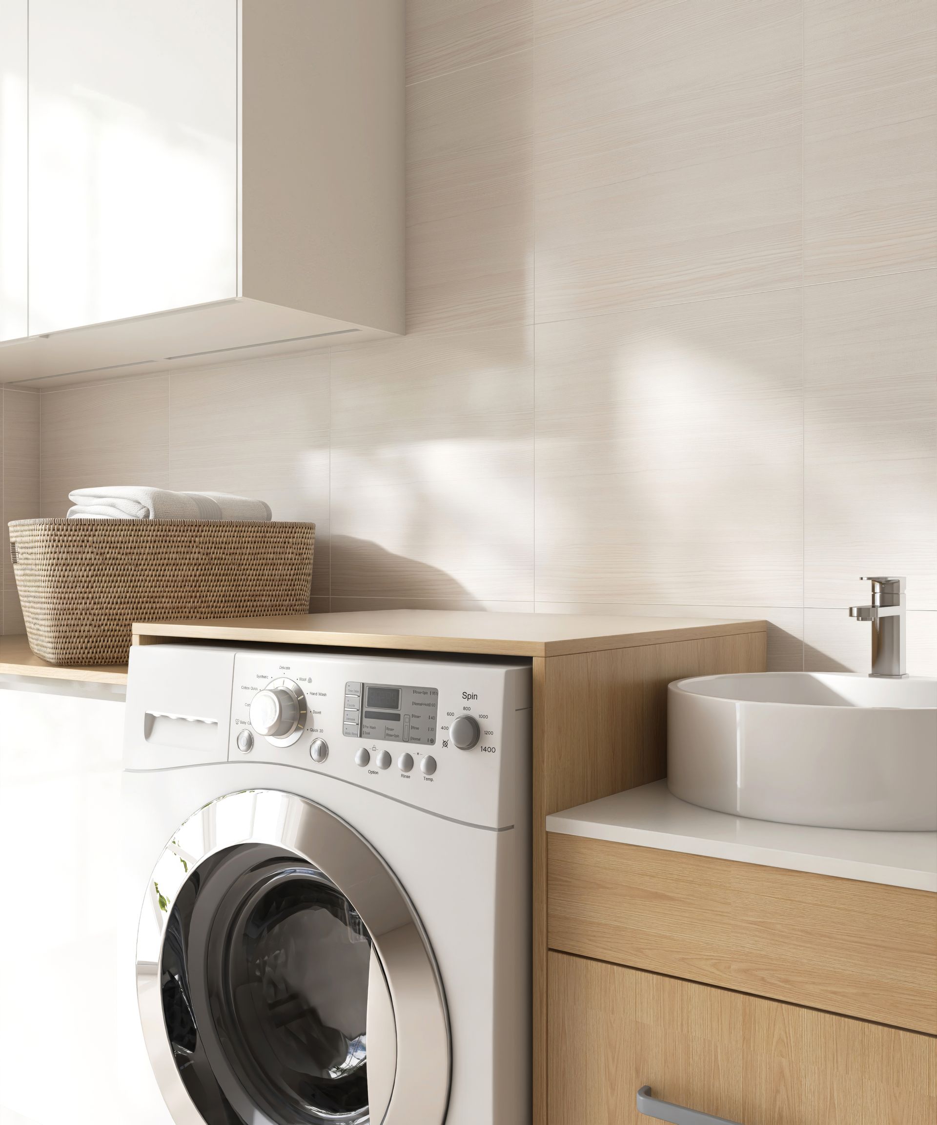 Washing machine in a laundry room, with a basket, sink, and wooden cabinets, all in neutral tones.
