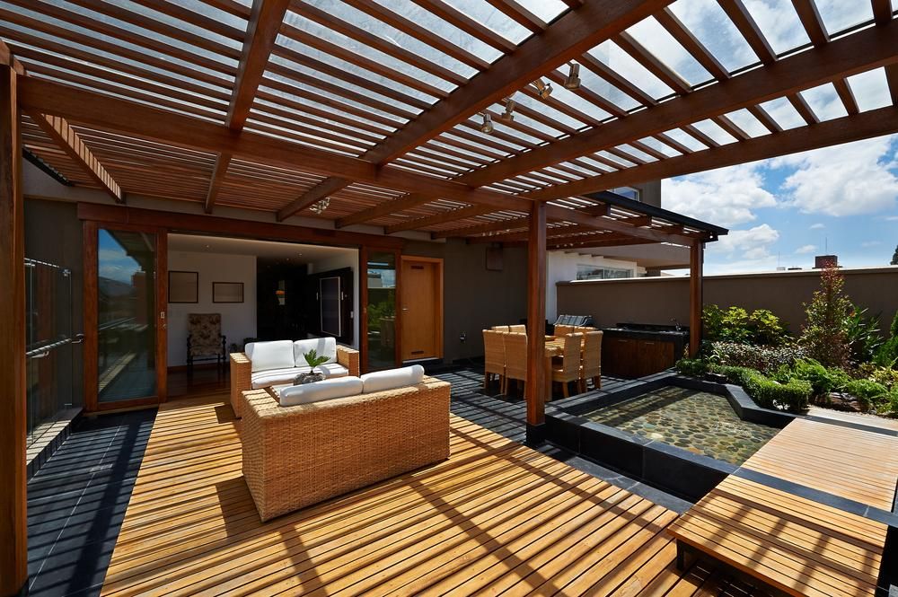 A Patio With a Pergola and a Couch and Chairs Underneath It — Norwood Floor Sanding in Ocean Shores, NSW