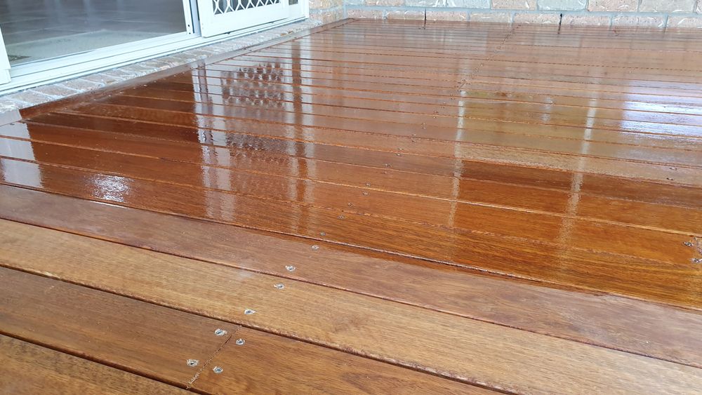 A Close Up of a Wooden Deck With a Reflection of a Window — Norwood Floor Sanding in Ocean Shores, NSW