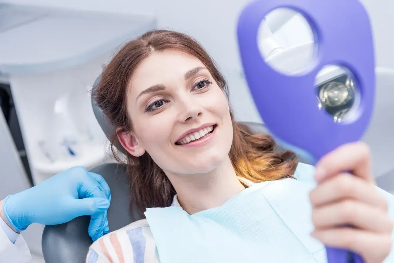 Woman Looking At Her Perfect Teeth — Runcorn, QLD — Runcorn Dental Woman Looking At Her Perfect Teeth — Runcorn, QLD — Runcorn Dental