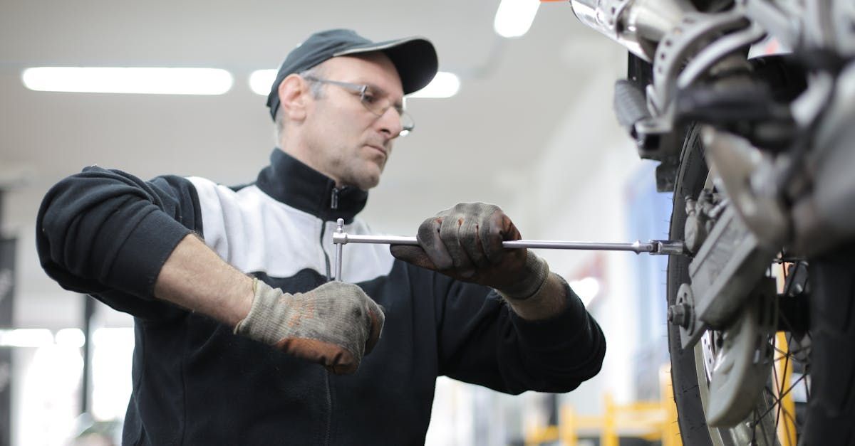 A man is working on a motorcycle with a wrench.