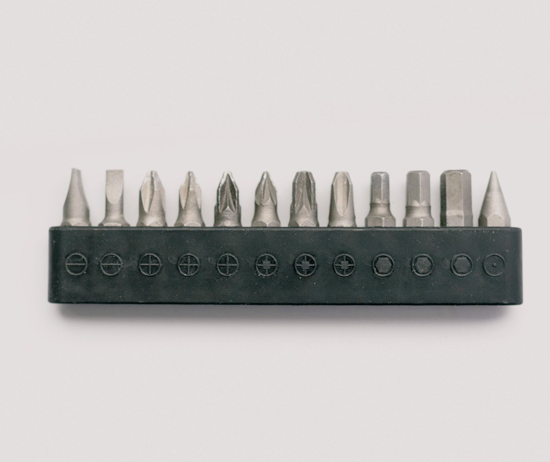 A set of screwdriver bits in a holder on a white background.