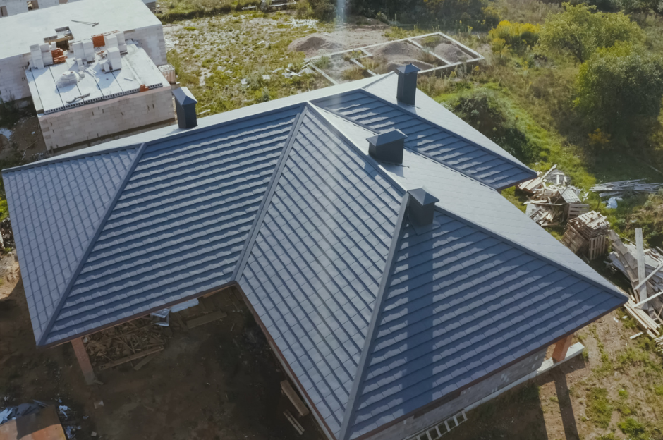 An aerial view of a house under construction with a black roof.