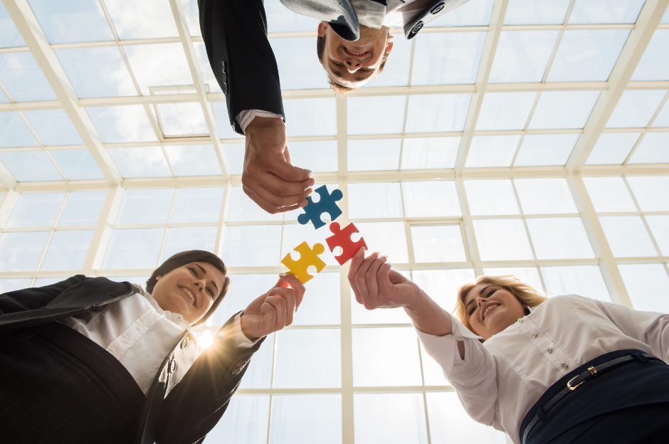 A group of business people are putting puzzle pieces together.