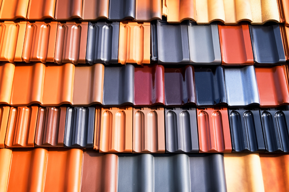 A row of roof tiles of different colors are stacked on top of each other.