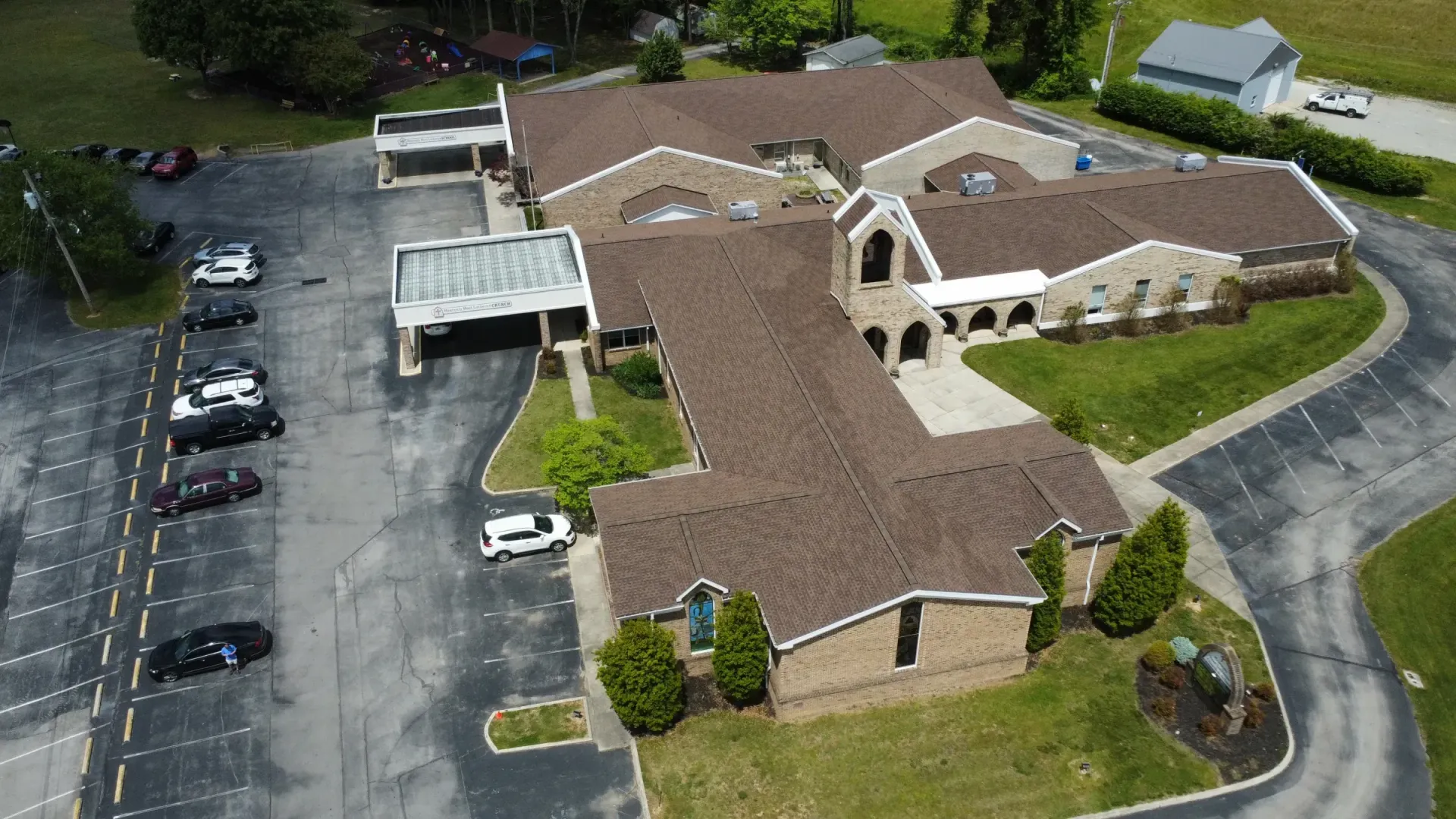 An aerial view of a large building with a parking lot in front of it.
