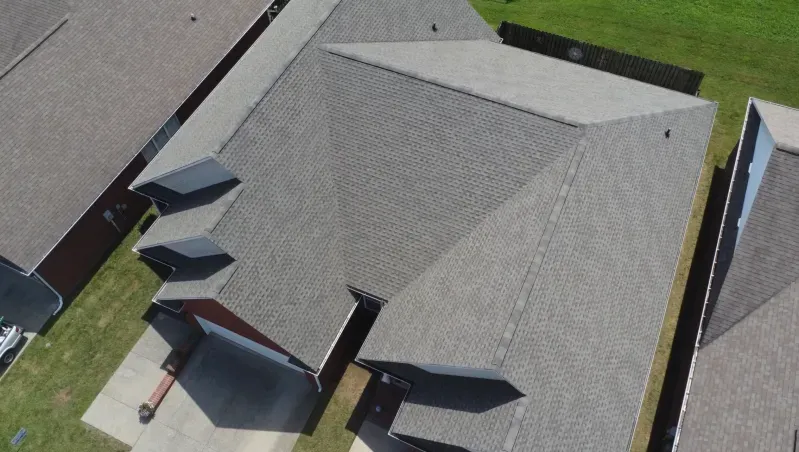 An aerial view of a roof of a house in a residential area.