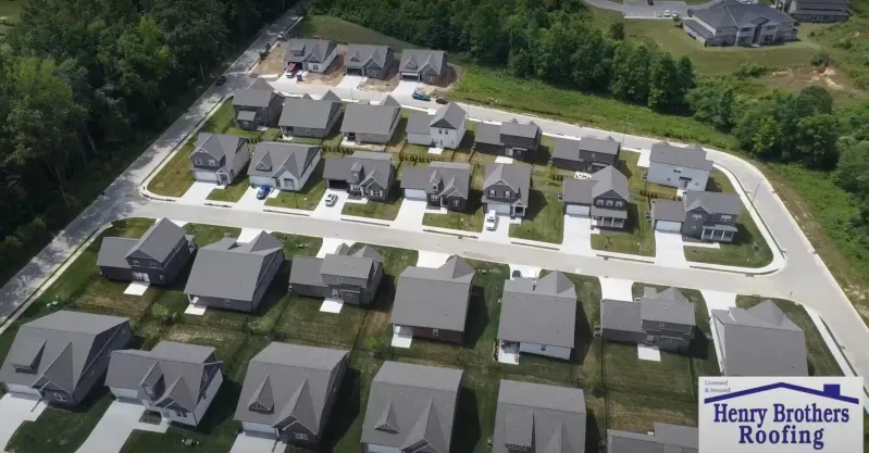An aerial view of a residential neighborhood with a henry brothers roofing logo