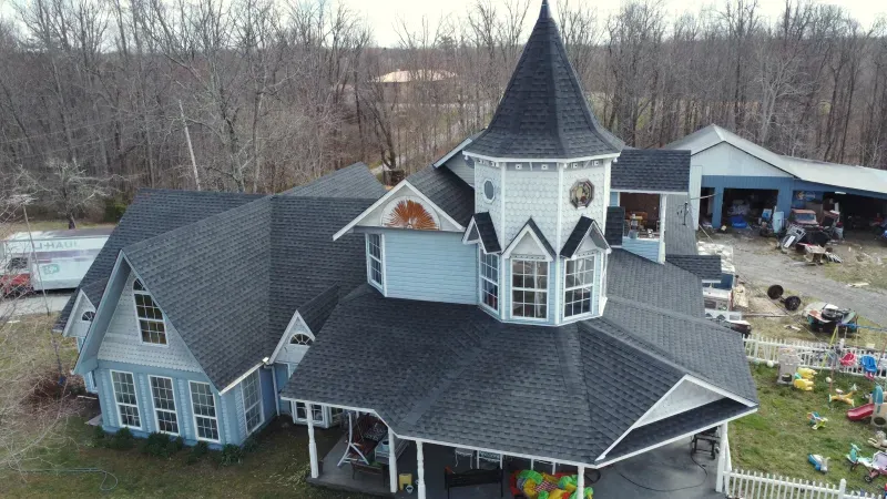 An aerial view of a large house with a tower on top of it.