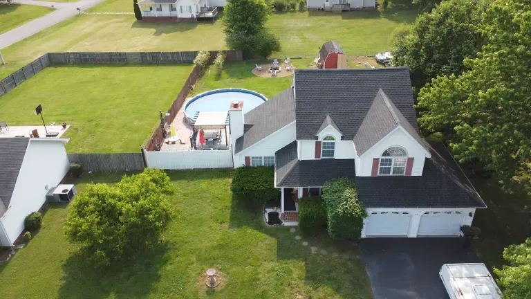 An aerial view of a house with a pool in the backyard