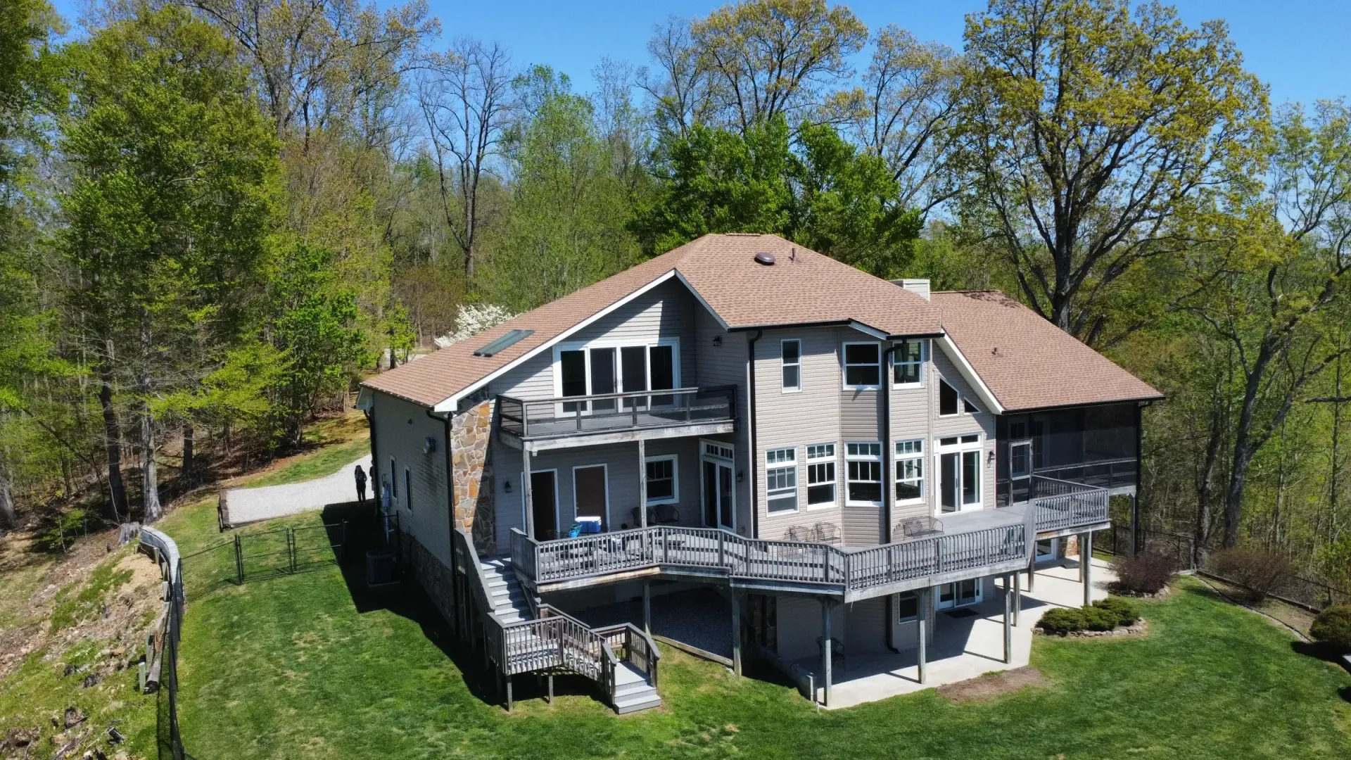 An aerial view of a large house on a hill surrounded by trees.
