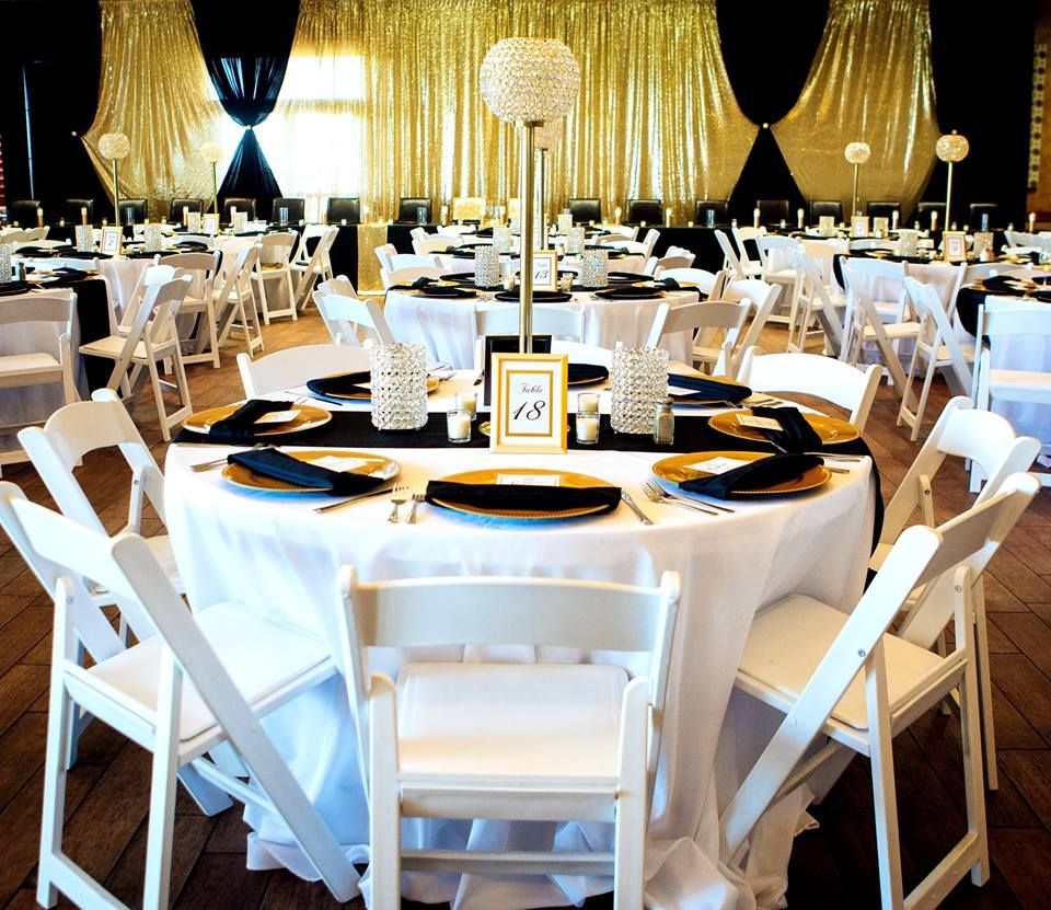 A large room with tables and chairs set up for a wedding reception