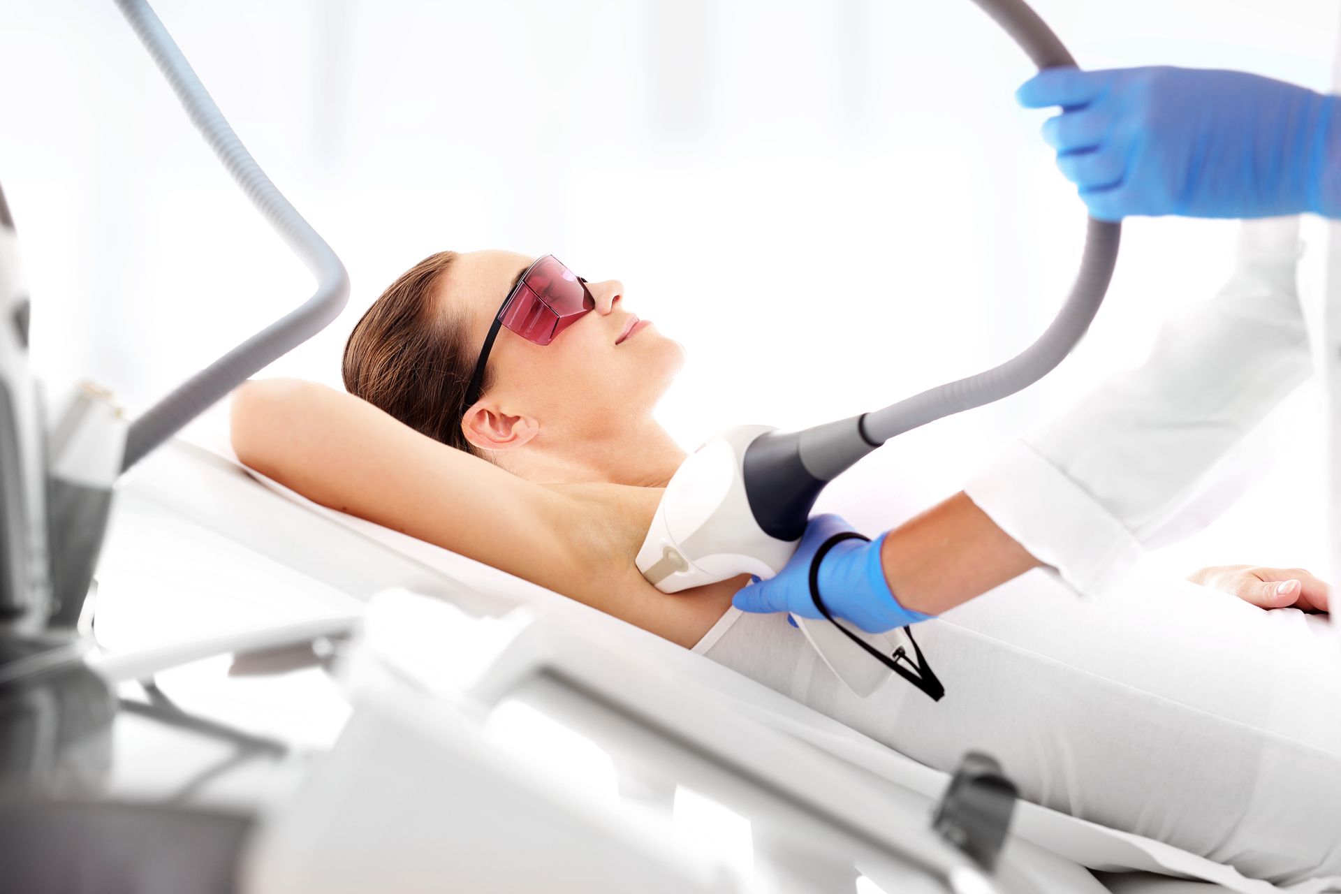 Woman receiving laser hair removal treatment on her underarm.