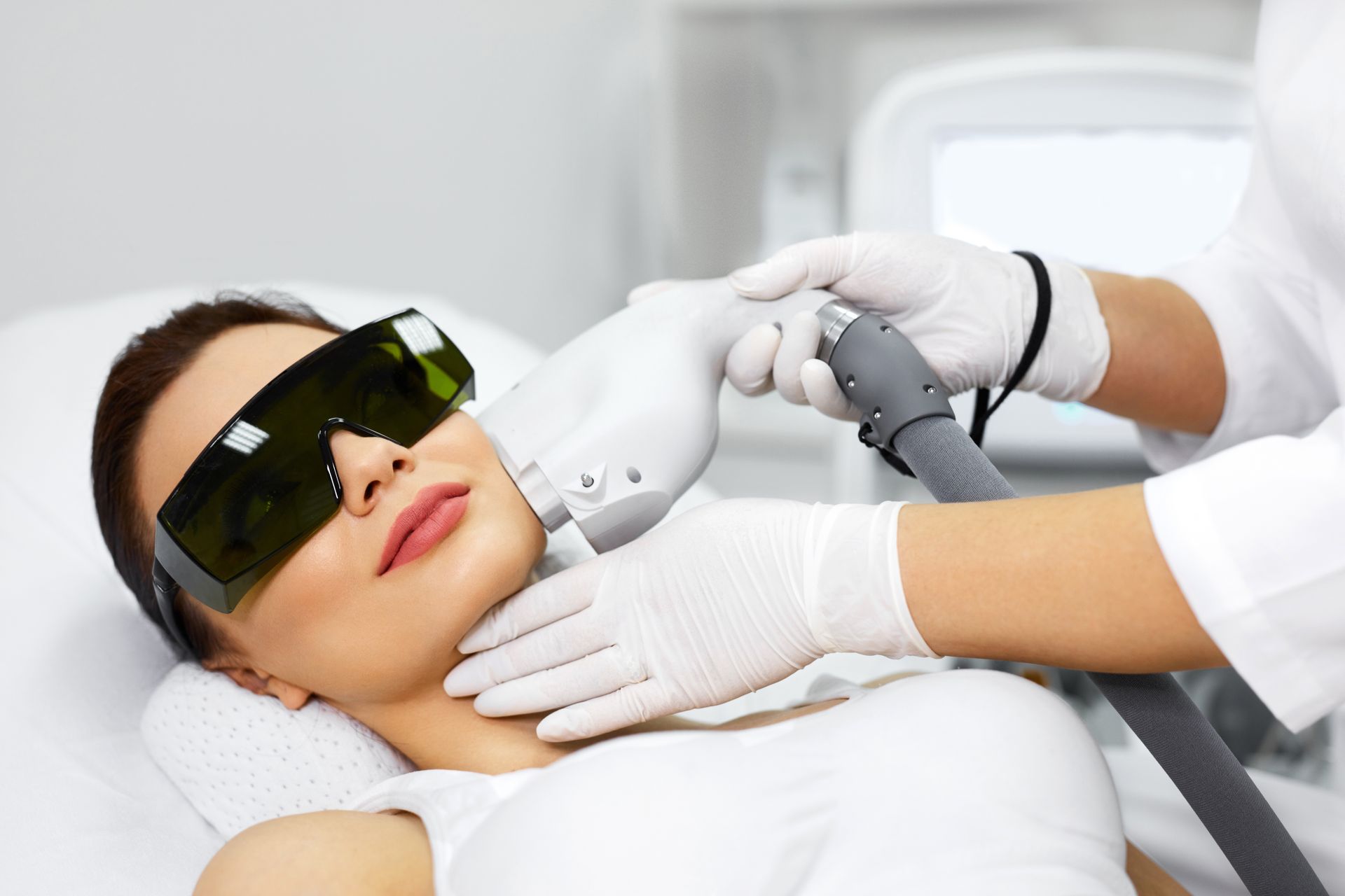 Woman receiving laser skin treatment on her face.