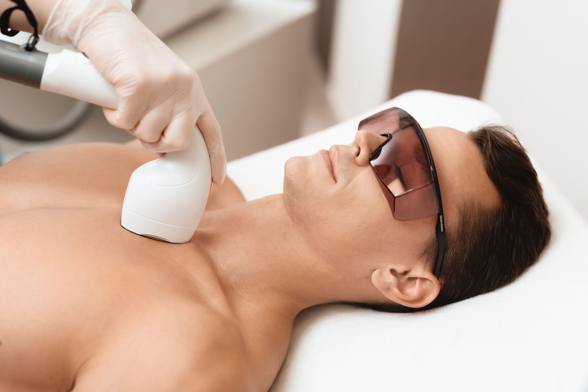 Man receiving laser hair removal treatment on his chest.