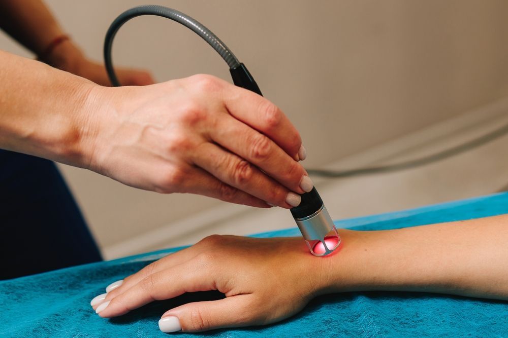 Woman receiving laser hair removal treatment on bikini area.