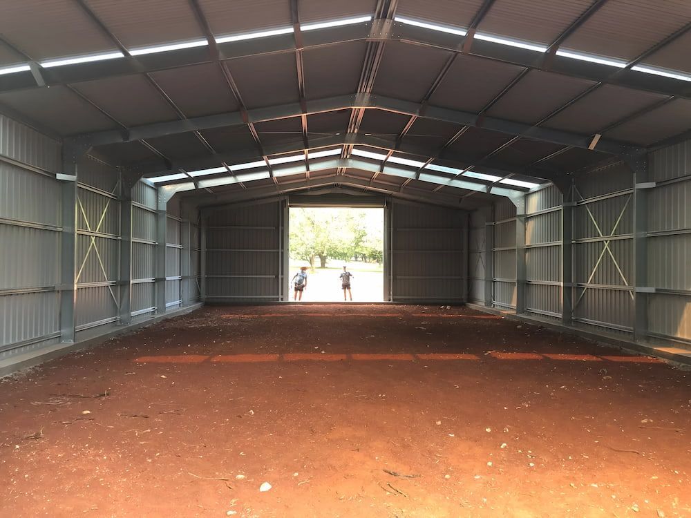 Inside of a Large, Empty Metal Shed, Two People Stand in the Doorway — Northern Rivers Sheds in South Lismore, NSW