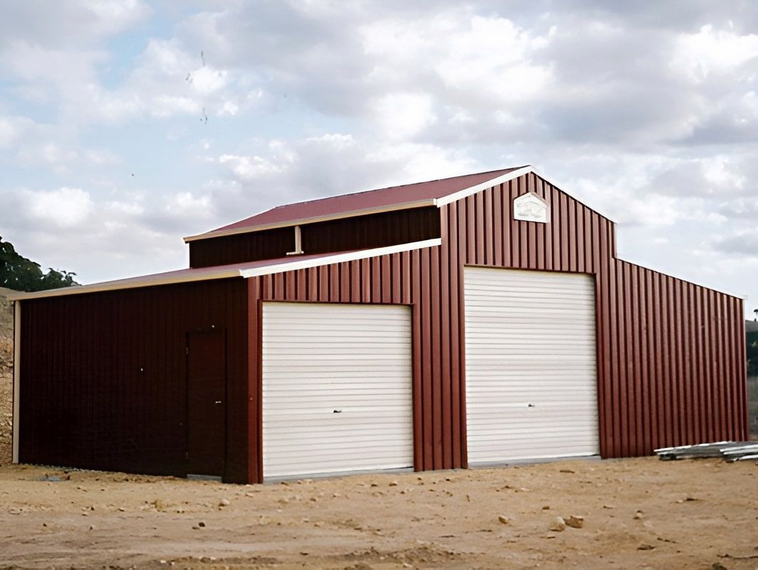 Red Metal Barn With White Garage Doors Under a Cloudy Sky — Northern Rivers Sheds in South Lismore, NSW