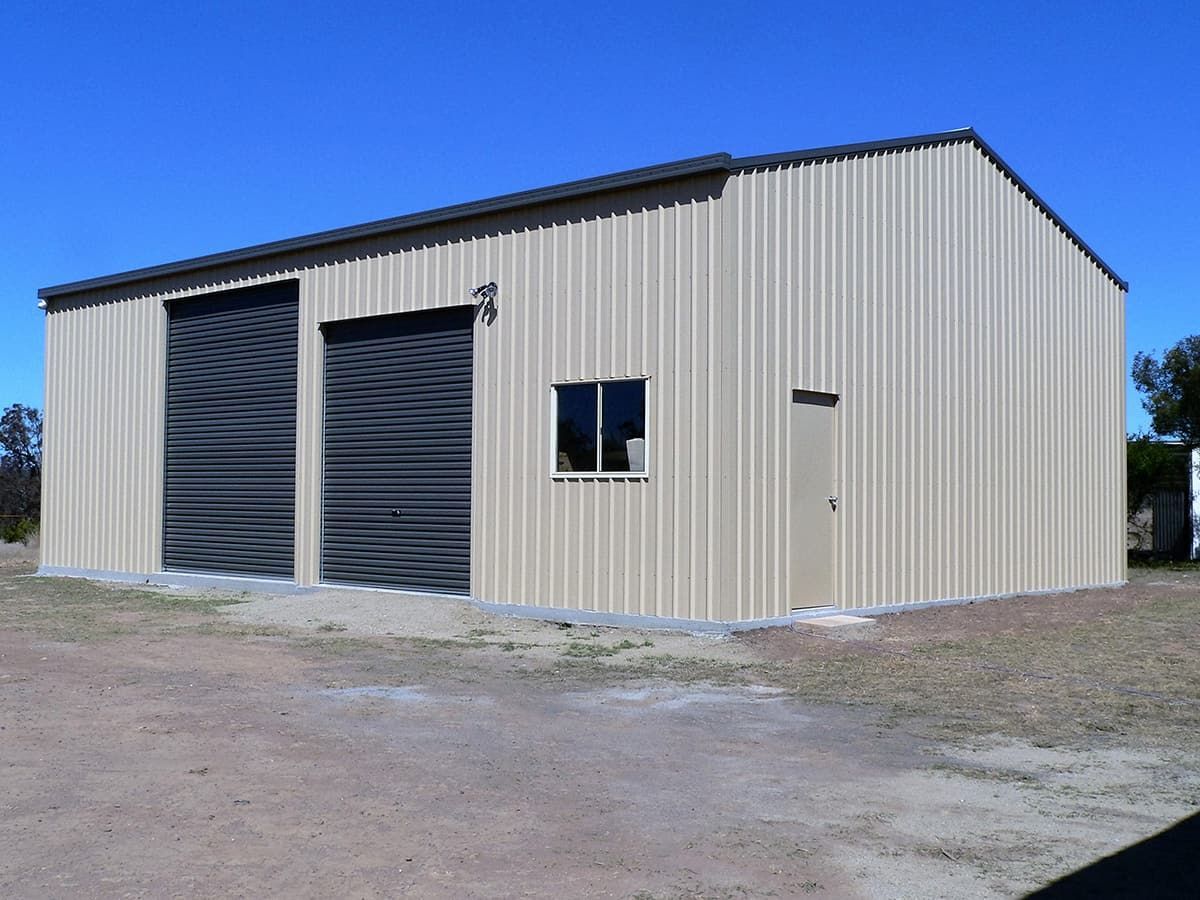 Tan Metal Shed With Two Gray Roller Doors, Small Window — Northern Rivers Sheds in South Lismore, NSW