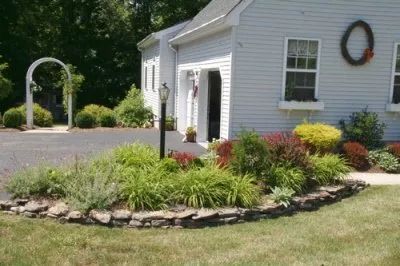 A white house with a garden in front of it.