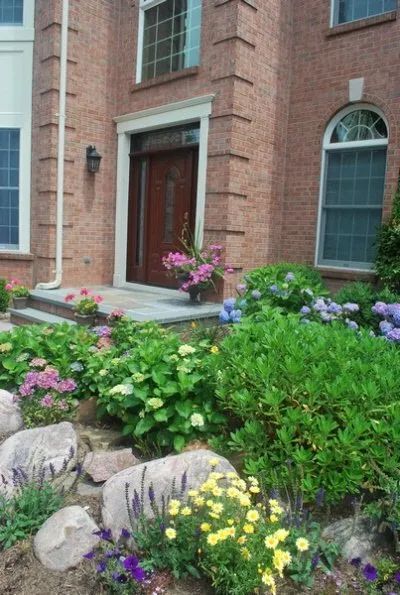 A brick house with flowers in front of it