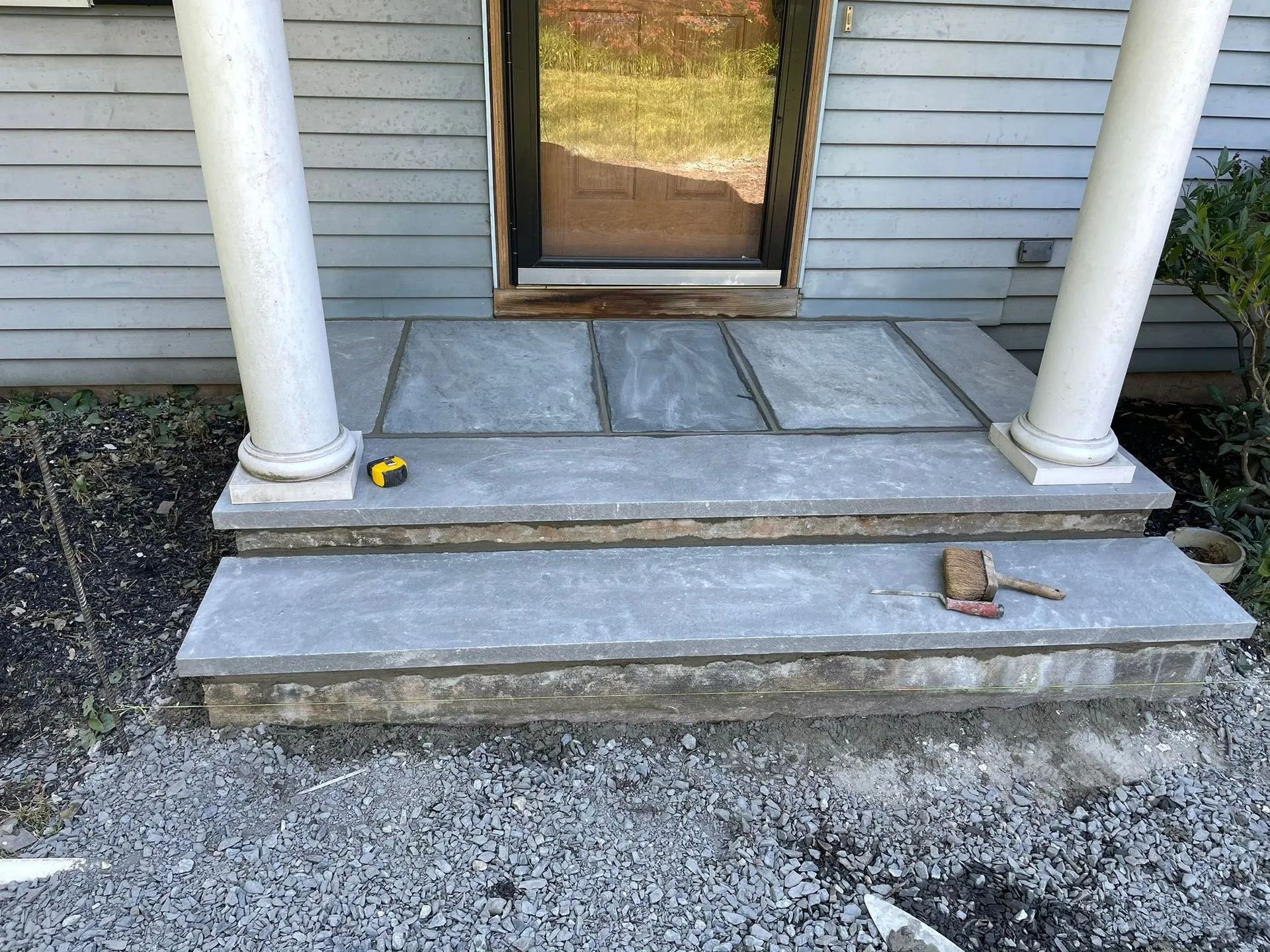 A porch with steps being built in front of a house.