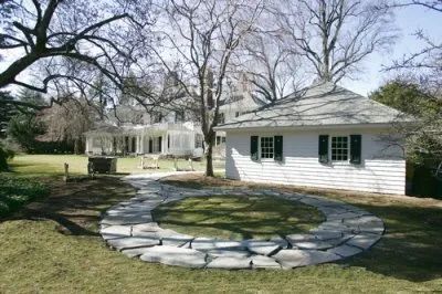 A white house with a stone patio in front of it