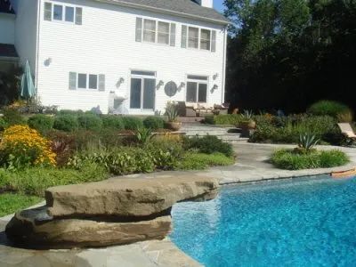 A large white house with a swimming pool in front of it