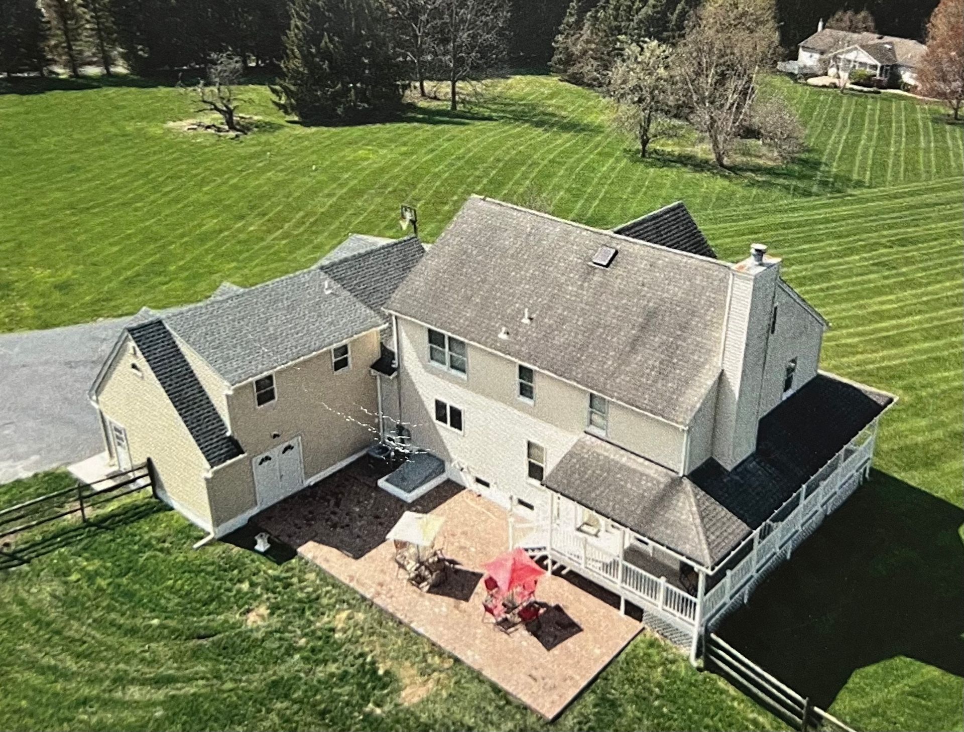 An aerial view of a large house with a large lawn in front of it.