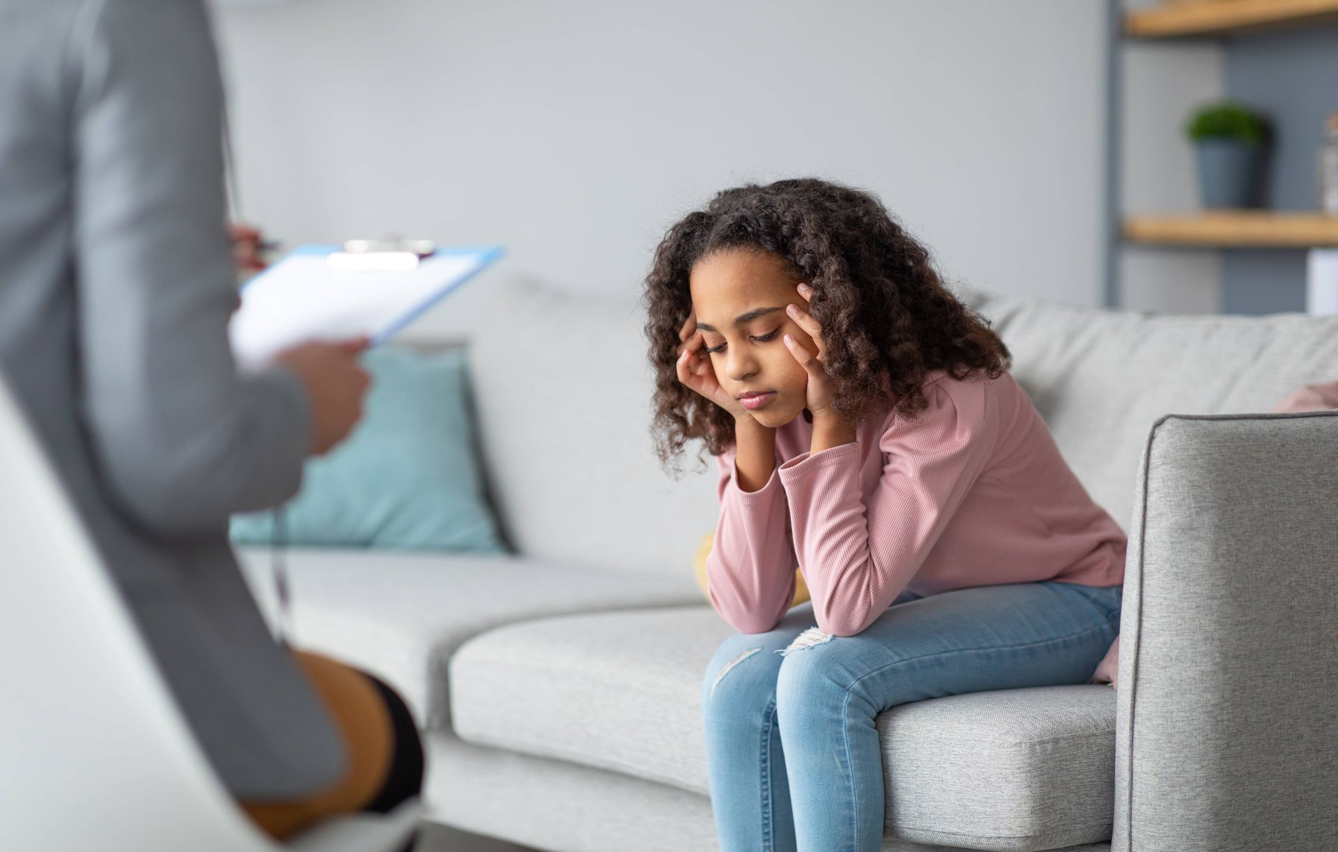 Therapist speaking to a distressed client seated on a sofa in a living room