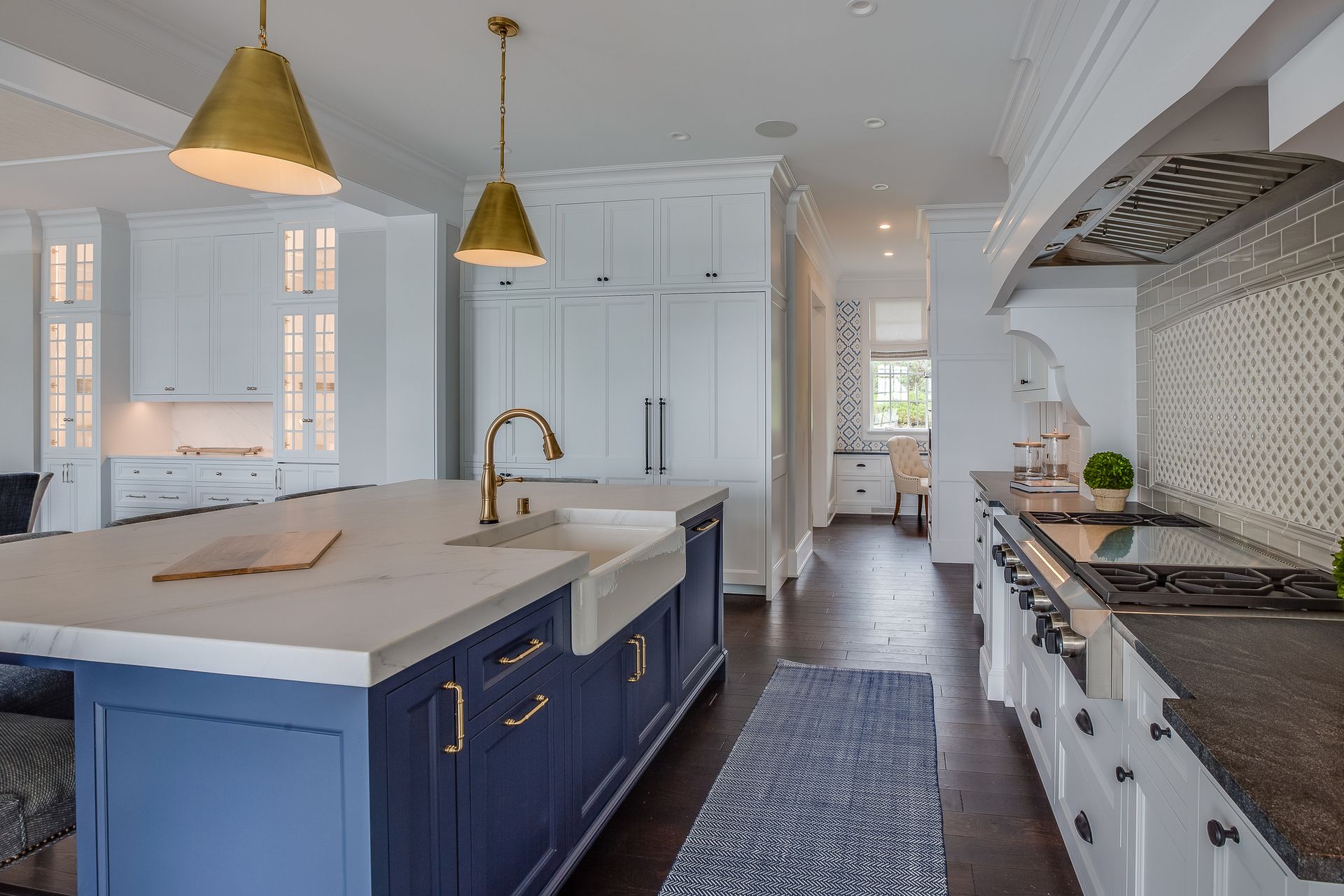 A kitchen with blue cabinets, white cabinets, and a large island.