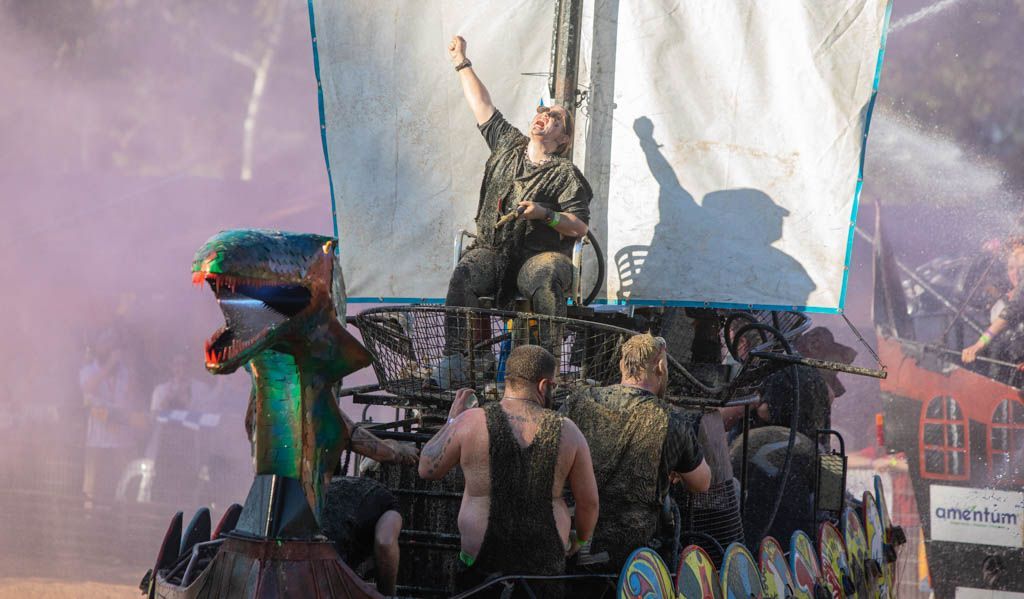 A group of people are standing on top of a boat.