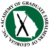 Circular logo with black text, green center, white map silhouette, and large black X in the middle