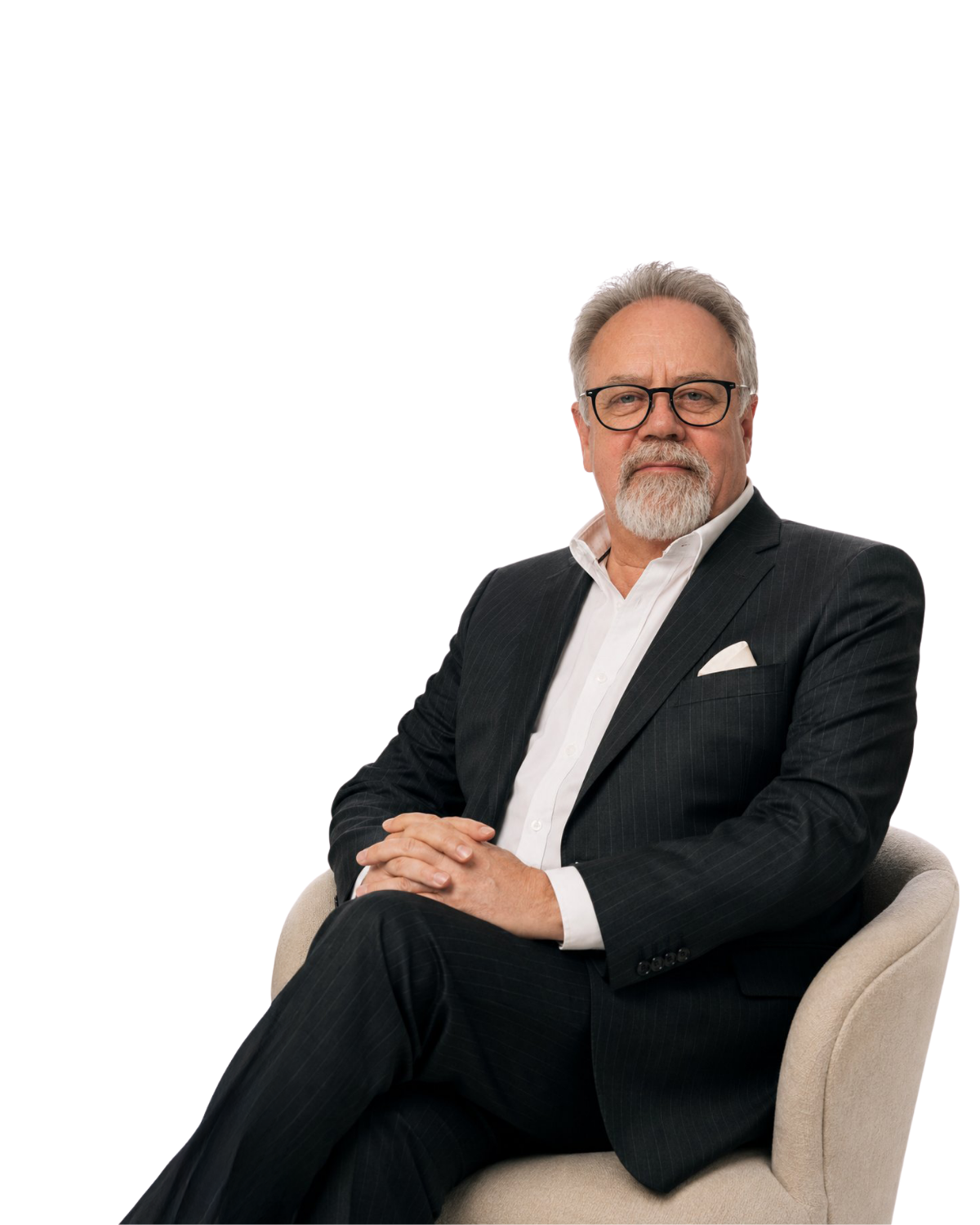 Seated man in a black suit and glasses on a beige chair against a white background