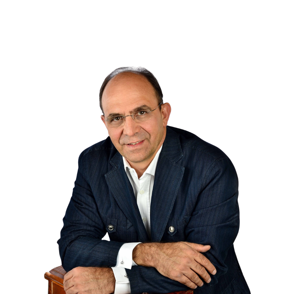 Portrait of a man in a dark blazer and white shirt, leaning on a chair against a white background