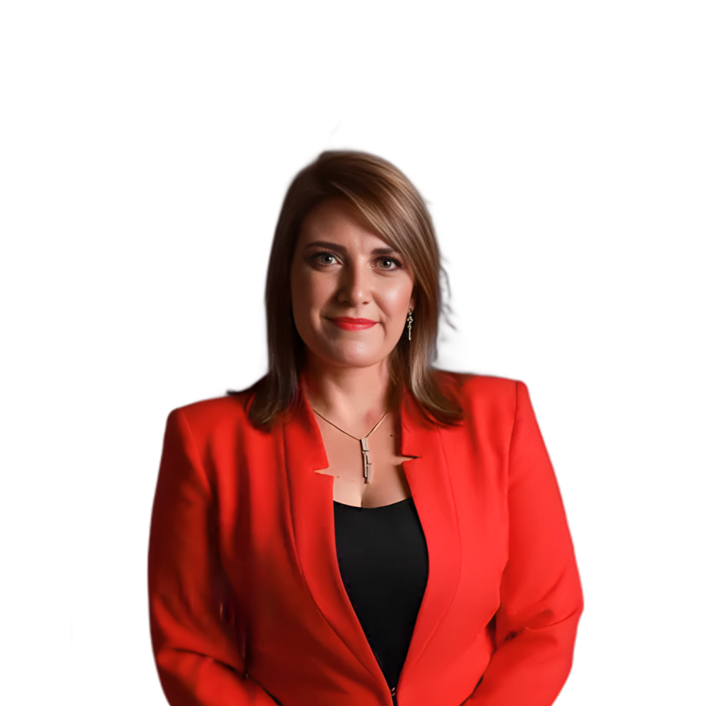 Woman in a red blazer and black top, standing against a white background with a slight smile