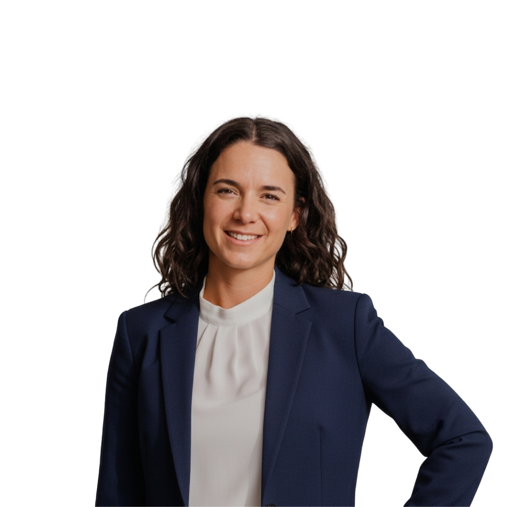 Smiling woman in a navy blazer and white blouse, standing against a white background.