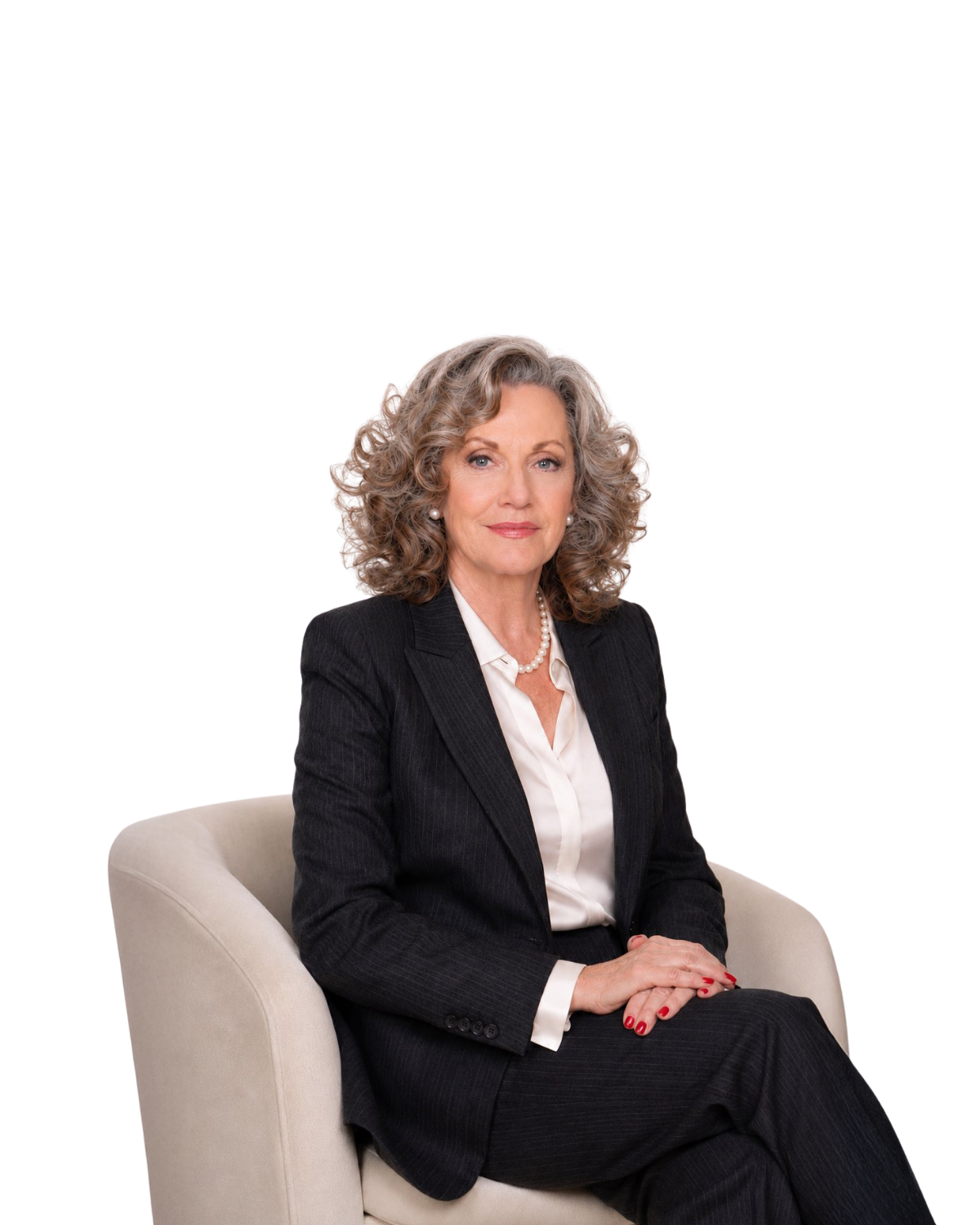 Woman in a black suit seated on a beige chair against a white background.
